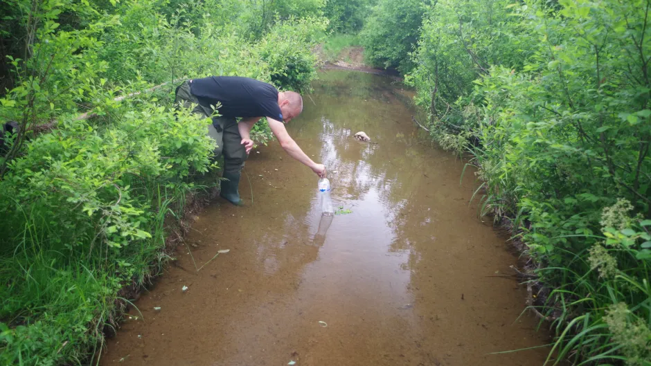 Tom Kirschey prüft Wasserstand in Dränage